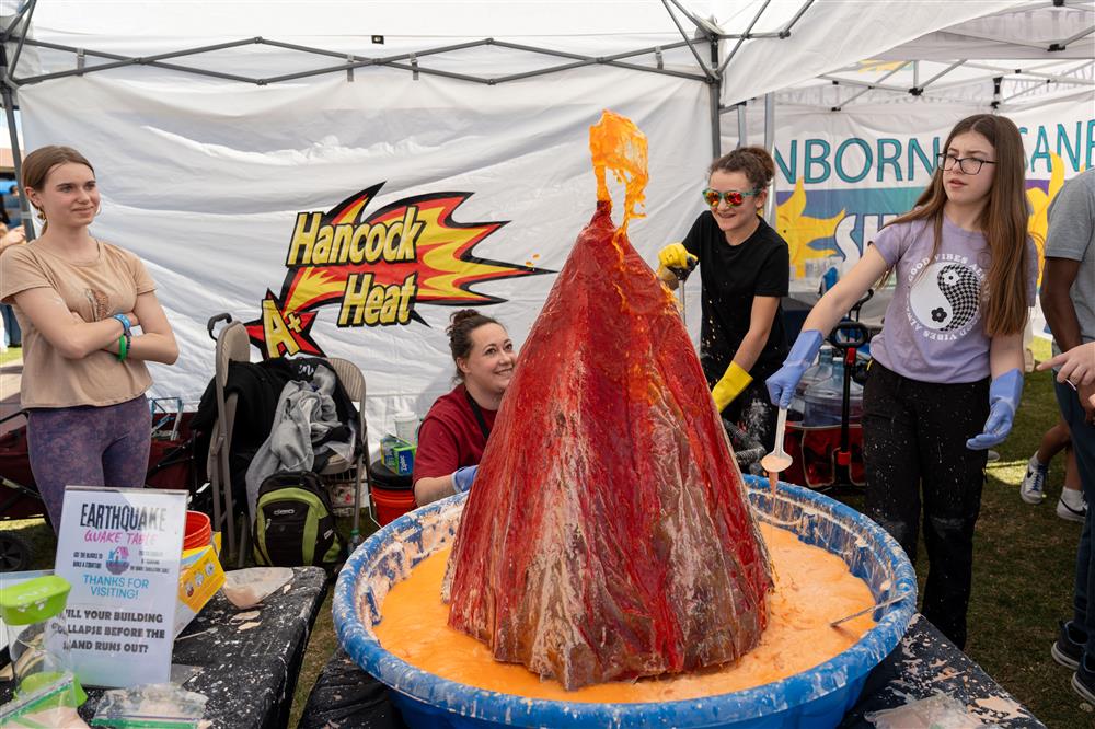 Hancock Elementary School students and staff members showcase a large paper mache volcano.